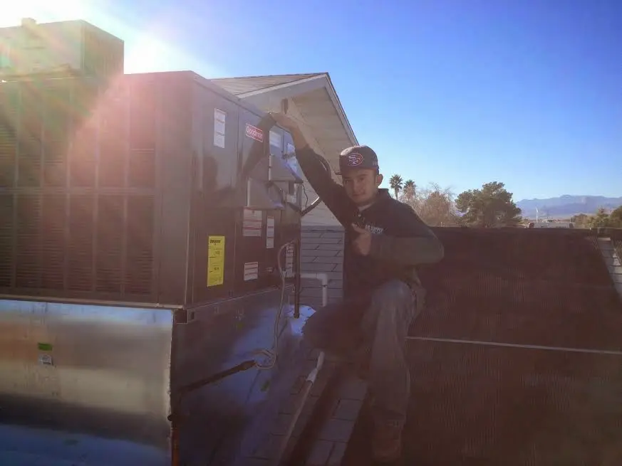 HVAC technician performing Air Duct Repair on a rooftop unit in Sandpoint